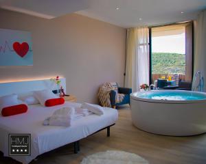 Habitación de hotel con bañera en un dormitorio en Hotel Spa Mirador, en Jorquera