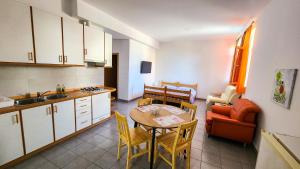 eine Küche und ein Wohnzimmer mit Tisch und Stühlen in der Unterkunft Apartments Dani in Izola