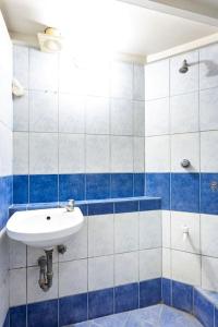 a blue and white bathroom with a sink and a shower at Casa Jessica 326 Heavens Place One bedroom plus loft Condo Unit in Bacoor