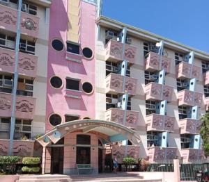 a pink apartment building with a large building at Casa Jessica 326 Heavens Place One bedroom plus loft Condo Unit in Bacoor