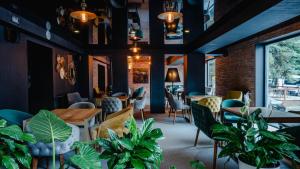 Bakuriani Inn في باكورياني: مطعم بالطاولات والكراسي والنباتات