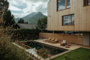 une maison avec une terrasse et une piscine dans l'établissement Haus Aerli, à Ehrwald