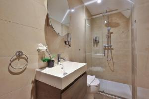 a bathroom with a sink and a shower and a toilet at Imperial Middlesex Street Apartments in London