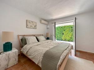 a bedroom with a bed and a large window at Casa di Campara Villa Faro in Faro
