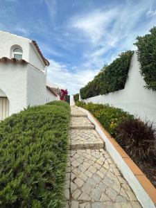 a stone path next to a white building at Casa di Campara Villa Faro in Faro