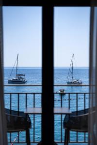 two boats in the ocean viewed from a window at Hotel California by Aycon in Sveti Stefan