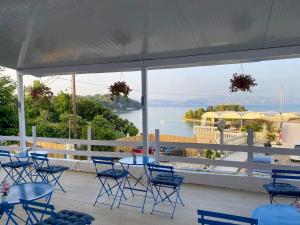 un patio con mesas y sillas y vistas al agua en Batis Breeze Suites en (( Filaréton ))