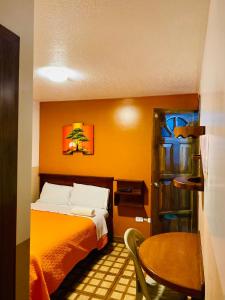 a small room with a bed and a table at Hostal Alpachaca - New Quito Airport in Tababela