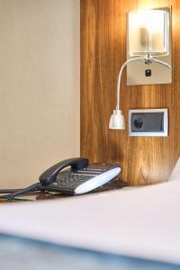 a telephone sitting on a desk with a lamp at VP Jardín de Recoletos in Madrid