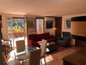 Angelo Emo Terrace في روما: غرفة معيشة مع أريكة حمراء وطاولة زجاجية