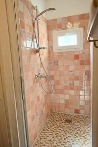 y baño con ducha de azulejos rosados. en Appartement avec grand jardin, en Cannes