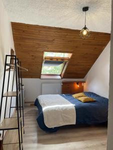 um quarto com uma cama e um tecto em madeira em Maison L'Aiguille - 2 appartements, 5 chambres et table d'hôtes au pied de la montagne à la station de Laye em Laye