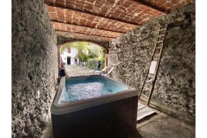 a bathroom with a bath tub in a stone wall at Cascina Liebe con Idromassaggio in Ozzano Monferrato