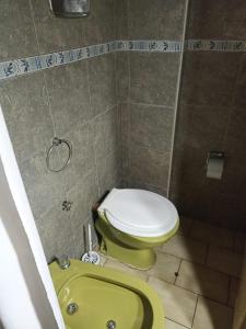 y baño con aseo y lavamanos verde. en Complejo las Palmeras II en Mendoza