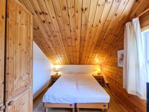 Łóżko w pokoju z drewnianym sufitem w obiekcie Chalet confortable avec poêle et terrasse, 3 chambres, garage, animaux admis - FR-1-425-198 w mieście Arâches-la-Frasse