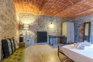 a bedroom with a bed and a stone wall at Cascina Liebe con Idromassaggio in Ozzano Monferrato