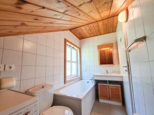 łazienka z wanną, toaletą i umywalką w obiekcie Chalet confortable avec poêle et terrasse, 3 chambres, garage, animaux admis - FR-1-425-198 w mieście Arâches-la-Frasse