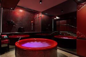 Metro Elegance Suites في Tel Binyamin: حمام مع حوض احمر ومغسلتين