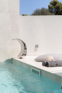 - une chambre avec une piscine à côté d'un lit dans l'établissement White Cliff Luxury Suites by A&D Properties, à Pórto Ráfti