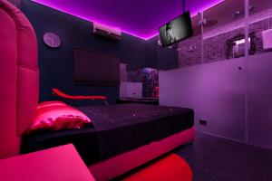 a pink bedroom with a bed and a tv at Metro Elegance Suites in Tel Binyamin