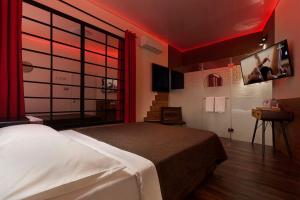 Metro Elegance Suites في Tel Binyamin: غرفة نوم بسرير كبير مع اضاءة حمراء
