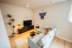 een woonkamer met een bank en een tv bij Astonishing 3 Bedroom Serviced Apartment 73m2 in Rotterdam