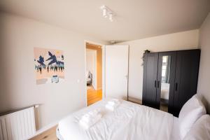 um quarto com uma cama branca com lençóis brancos em Astonishing 3 Bedroom Serviced Apartment 73m2 em Roterdã