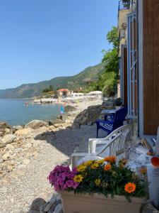 een groep stoelen en bloemen op een strand bij Villa Bella Sera in Scilla