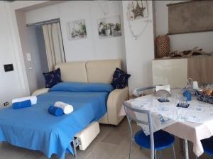 een slaapkamer met een bed en een tafel en een tafel bij Villa Bella Sera in Scilla