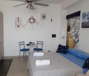 a bedroom with a bed with two chairs and a table at Villa Bella Sera in Scilla