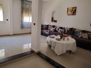 un soggiorno con tavolo e divano di Apartement en 1er etage et autre 2eme avec terasse location longue duré a Essaouira