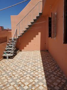 a staircase on the side of a building with a tiled floor at Apartement en 1er etage et autre 2eme avec terasse location longue duré in Essaouira