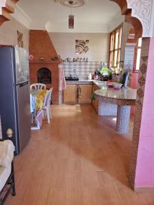 a kitchen with a stainless steel refrigerator and wooden floors at Apartement en 1er etage et autre 2eme avec terasse location longue duré in Essaouira