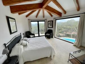 um quarto com uma cama e uma grande janela em ESCAPADA em Tamariu
