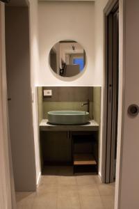 een badkamer met een wastafel en een spiegel bij MONACHILE APARTMENTS in Polignano a Mare