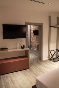 een slaapkamer met een grote televisie aan de muur bij MONACHILE APARTMENTS in Polignano a Mare