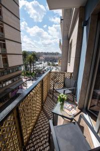balcone con tavoli, sedie e vista sulla città di Contemporaneamente 147 - Modern & Comfort Rooms a Bari