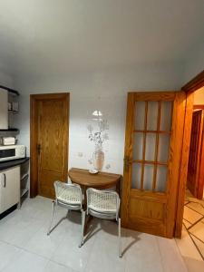 a kitchen with a wooden table and two chairs at Mccoy avenida 3 in Macael