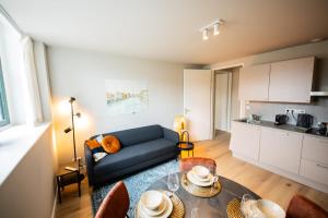 ein Wohnzimmer mit einem Sofa und einem Tisch in der Unterkunft Balanced 3 Bedroom Serviced Apartment 68m2 in Rotterdam