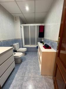 a bathroom with a toilet and a sink at Precioso piso con piscina a 10 min de la playa andando in Roquetas de Mar