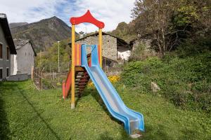 a group of playground slides in the grass at Suite Bertines Panoramica - Borgata di montagna in Casteldelfino