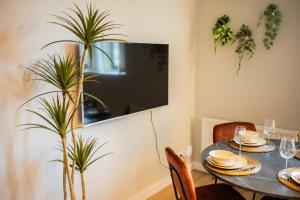uma sala de jantar com uma mesa e uma planta em Cool 3 Bedroom Serviced Apartment 68m2 em Roterdã