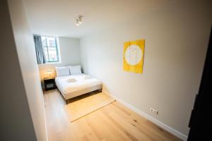 um quarto com uma cama e uma fotografia na parede em Cool 3 Bedroom Serviced Apartment 68m2 em Roterdã