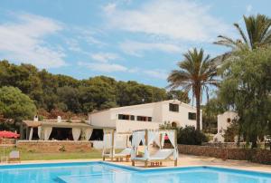 a villa with a swimming pool and a house at Llucatx Menorca in Son Parc