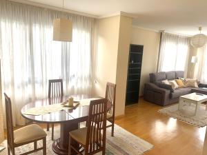 sala de estar con mesa y sofá en Apto La Manzanina con Parking, en Villaviciosa