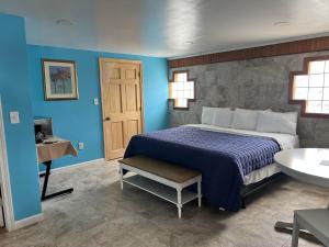 1 dormitorio con 1 cama con pared azul en Nautical Motel, en Hampton