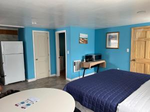 sypialnia z niebieskimi ścianami, łóżkiem i stołem w obiekcie Nautical Motel w mieście Hampton