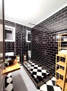 Voukamvilia Boutique Apartment في Ágios Matthaíos: حمام به أرضية مصدية سوداء وبيضاء