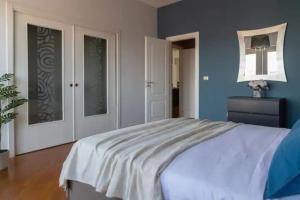 1 dormitorio con 1 cama grande y paredes azules en Etna City Home Accogliente nel cuore di Catania, en Catania