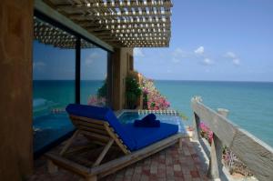 una silla azul sentada en un porche con vistas al océano en Cala Margarita Hotel, en Paraguchi